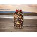 A bag of Golden Sands Potpourri by Irish Twins Potpourri on a beach with a lake in the background, capturing a classic, masculine fragrance.